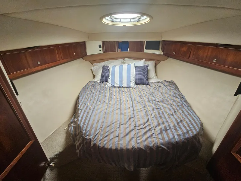 Slide: The Image of Cozy bedroom in 2008 Riviera M470 yacht with striped bedding and wooden cabinets. - 25