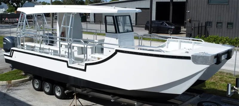 The Image of Custom 34 model boat, 2025, on trailer, white and black design, docked outdoors. - 1