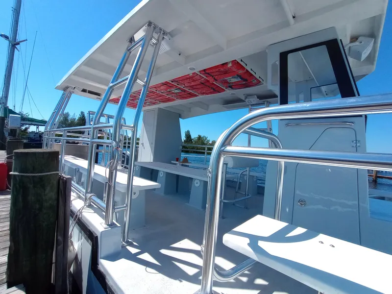 Slide: The Image of Custom 34 boat, 2025 model, docked with sleek metal railings and spacious seating area. - 12