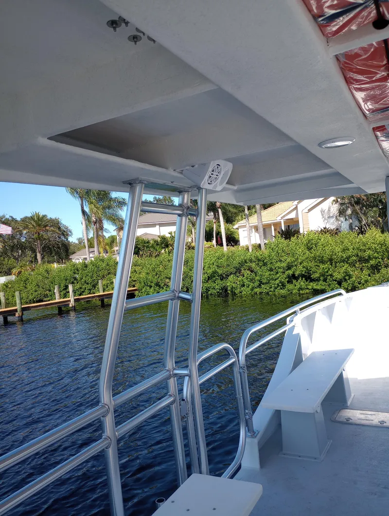 Slide: The Image of Custom 34 boat, 2025 model, docked by lush greenery and waterfront homes. - 13