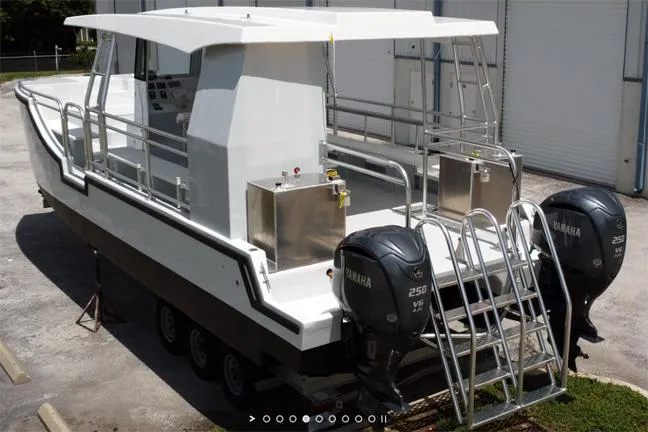 Slide: The Image of Custom 34 boat, 2025 model, with dual Yamaha outboard engines, docked on a trailer. - 2