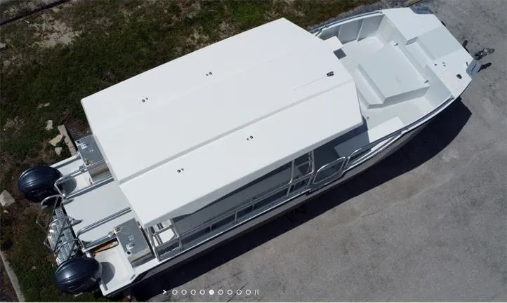 Slide: The Image of Aerial view of a 2025 Custom Model 34 boat with dual outboard motors. - 5