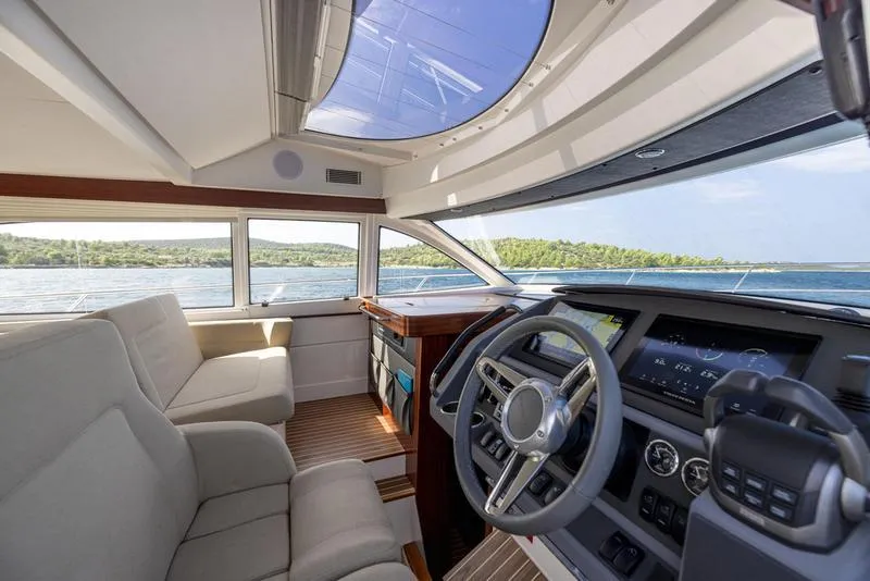 Slide: The Image of Interior of 2025 Nimbus 405 Flybridge yacht with modern helm and seating. - 12