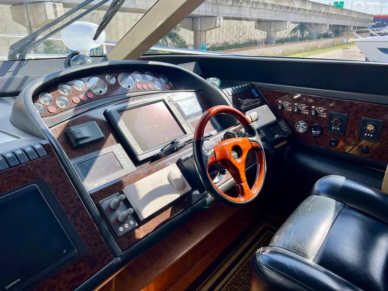 Slide: The Image of 2008 Viking Sport Cruisers 70 Motor Yacht helm with wood steering wheel and navigation instruments. - 19