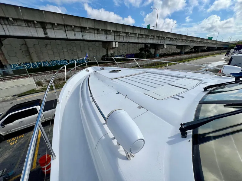Slide: The Image of 2008 Viking Sport Cruisers 70 Motor Yacht deck view, docked near a highway under a blue sky. - 5