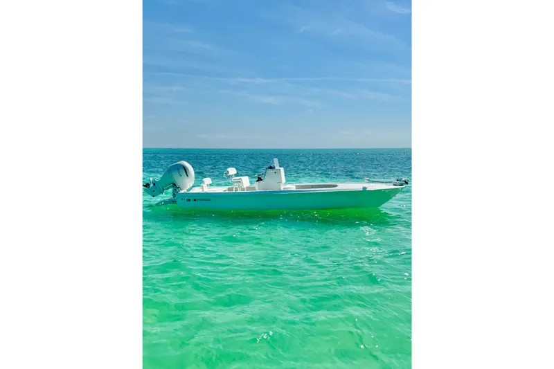 Slide: The Image of 2025 Contender 26 Bay boat on clear turquoise water under blue sky. - 12
