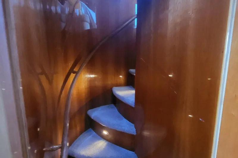 Slide: The Image of Curved wooden staircase inside 2000 Horizon 74 Motor Yacht, featuring carpeted steps. - 46