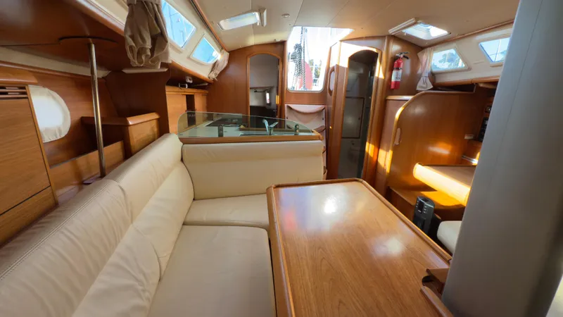 Slide: The Image of Interior of 2004 Jeanneau Sun Fast 35 sailboat, featuring cozy seating and wooden finishes. - 10