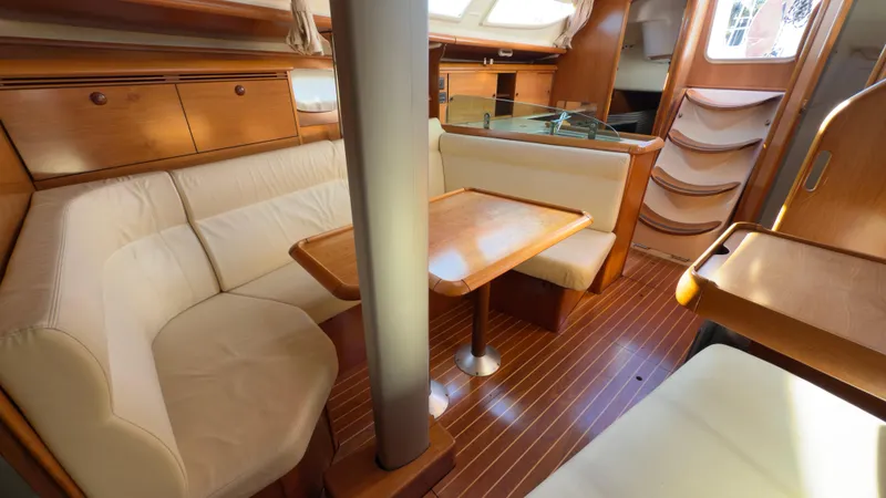 Slide: The Image of Interior of 2004 Jeanneau Sun Fast 35 sailboat with wooden furnishings and cozy seating. - 11