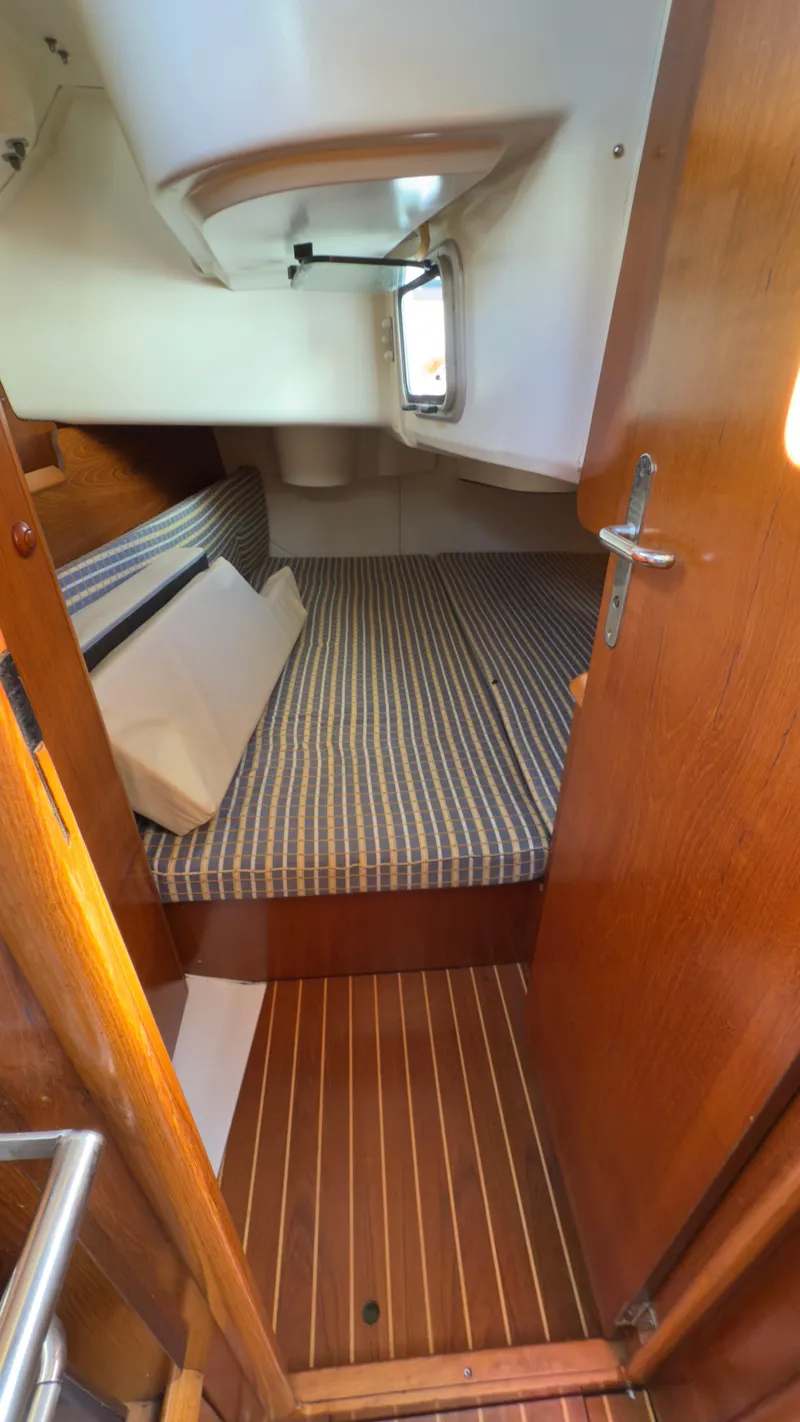 Slide: The Image of Cabin interior of 2004 Jeanneau Sun Fast 35 sailboat with striped bedding and wooden finishes. - 17