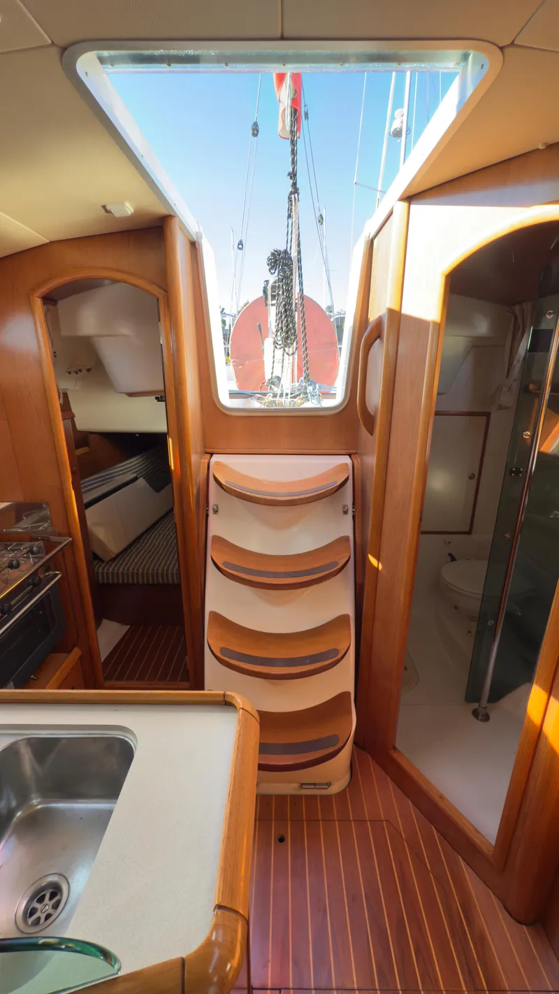 Slide: The Image of Interior of 2004 Jeanneau Sun Fast 35 sailboat, featuring wood cabinetry and a skylight. - 19
