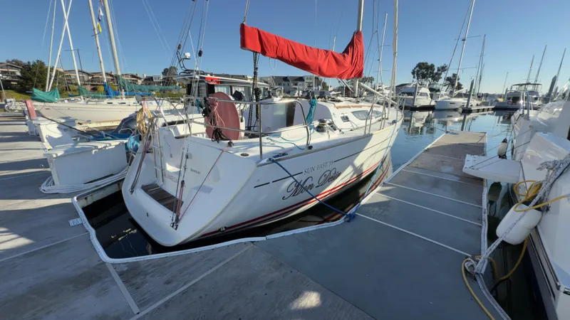 Slide: The Image of 2004 Jeanneau Sun Fast 35 sailboat docked at marina with red sail cover. - 3