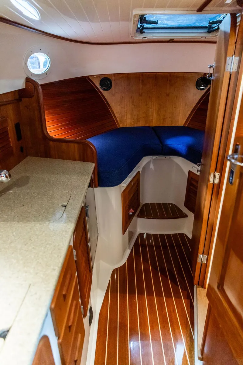 Slide: The Image of Interior of 2014 Hinckley Talaria 34 with fish-patterned seating and wooden accents. - 15