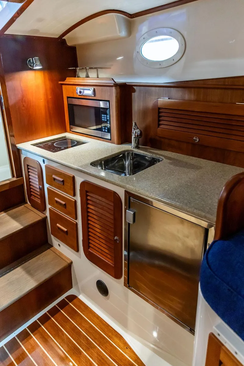 Slide: The Image of Interior of 2014 Hinckley Talaria 34 with elegant wood finish and patterned upholstery. - 14