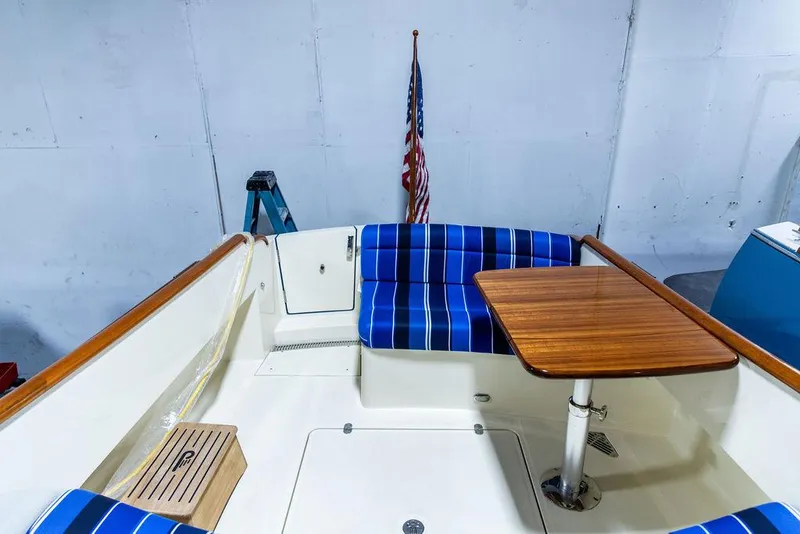 Slide: The Image of 2014 Hinckley Talaria 34 interior with blue-striped seating and wooden accents. - 4