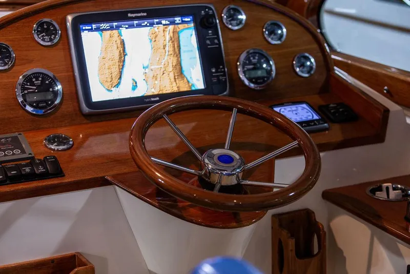 Slide: The Image of Hinckley Talaria 34, 2014 model, featuring elegant wooden and blue leather seating. - 9
