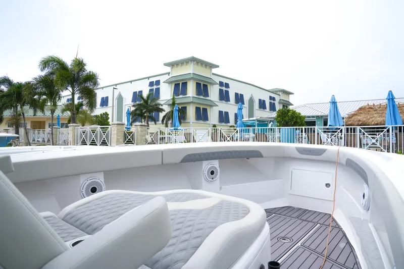 Slide: The Image of 2023 Front Runner 39 CC boat interior with luxury seating, docked near a tropical resort. - 11