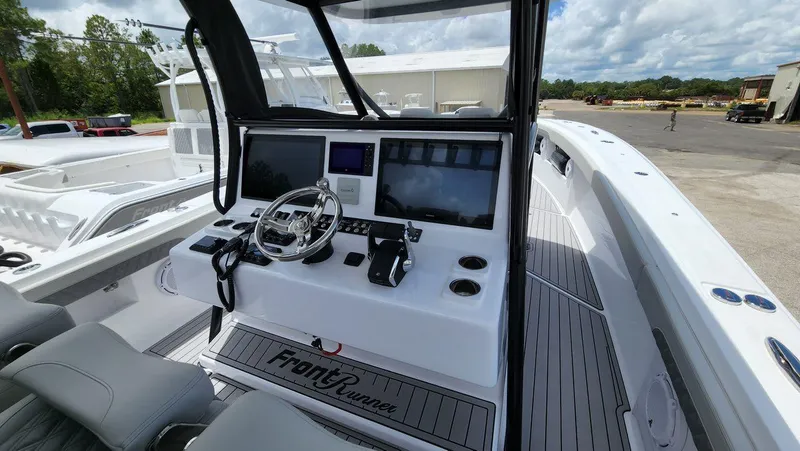 Slide: The Image of 2023 Front Runner 39 CC boat dashboard with modern controls and steering wheel. - 13