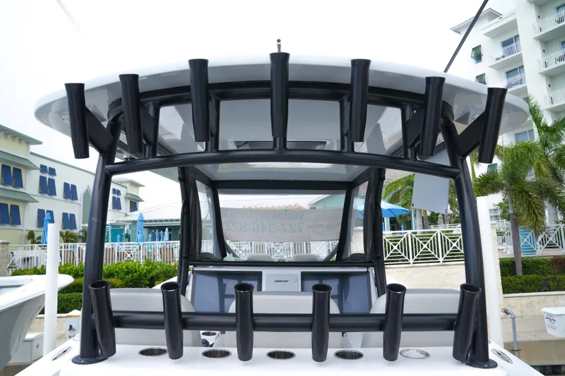 Slide: The Image of 2023 Front Runner 39 CC boat with multiple rod holders, docked near a resort. - 4