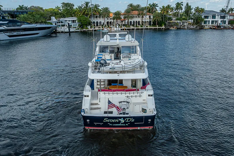 Slide: The Image of 2013 Johnson 78 Cockpit Motoryacht on water, rear view, luxury waterfront homes in background. - 10