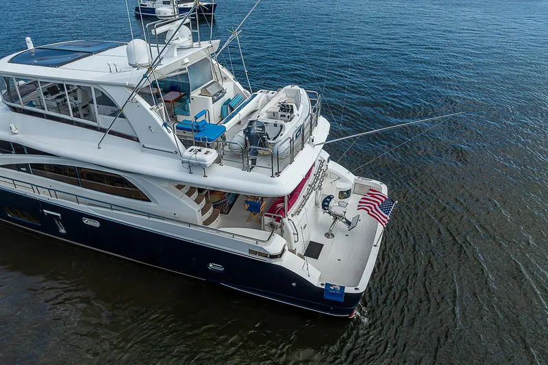 Slide: The Image of Johnson 78 Cockpit Motoryacht 2013 on water, aerial view, American flag displayed. - 12
