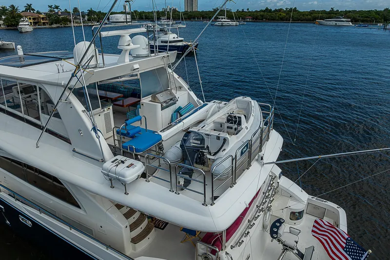 Slide: The Image of 2013 Johnson 78 Cockpit Motoryacht docked, featuring upper deck and water view. - 13