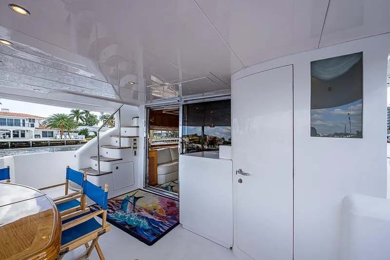 Slide: The Image of 2013 Johnson 78 Cockpit Motoryacht interior with seating, stairs, and waterfront view. - 17