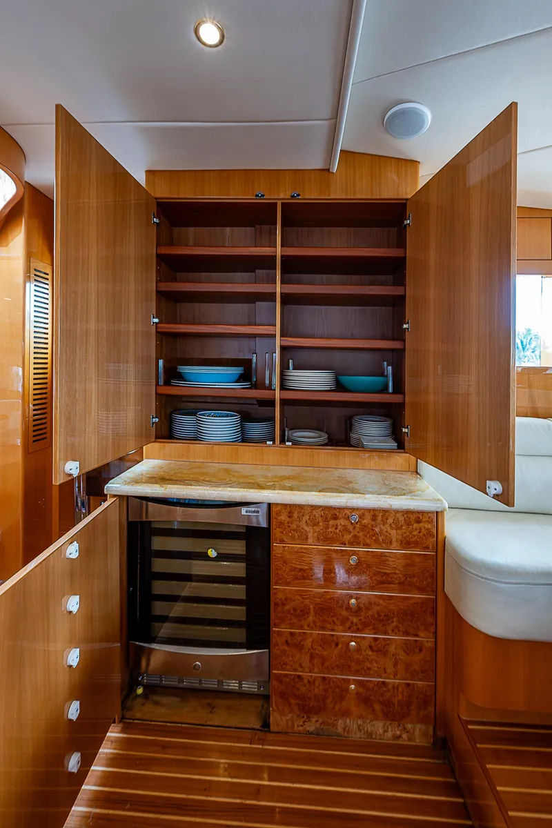 Slide: The Image of Luxurious interior of 2013 Johnson 78 Cockpit Motoryacht with wooden cabinetry and wine cooler. - 29