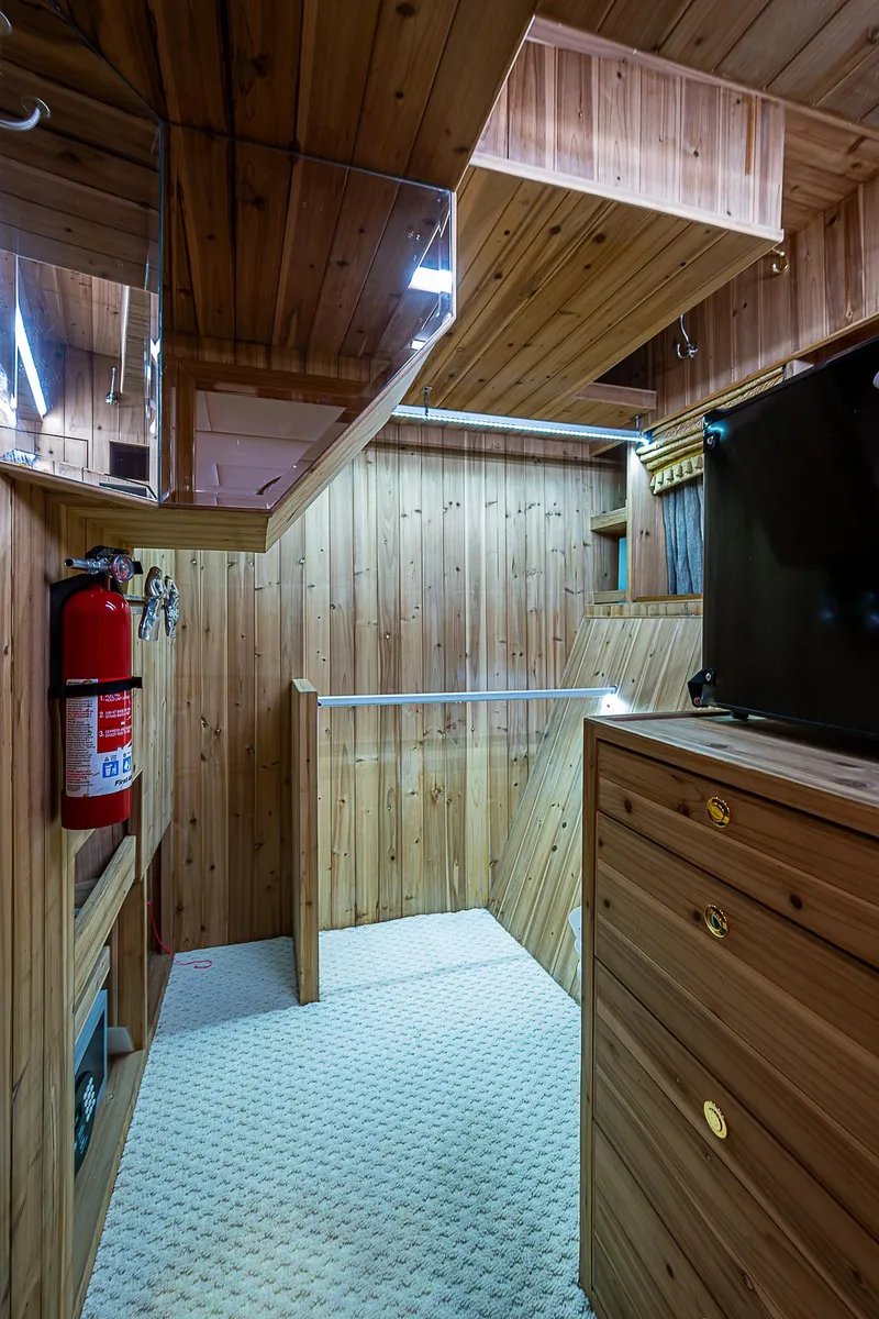 Slide: The Image of Wood-paneled interior of 2013 Johnson 78 Cockpit Motoryacht with fire extinguisher and storage. - 37