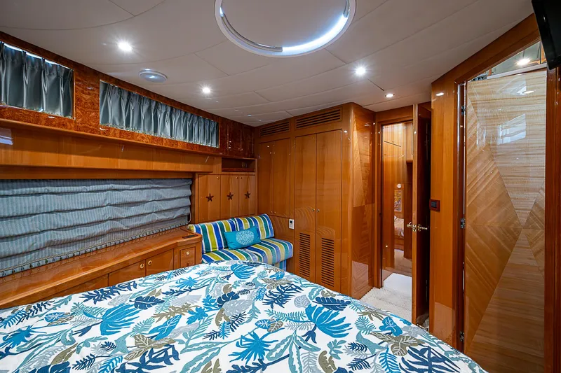 Slide: The Image of Luxurious cabin interior of 2013 Johnson 78 Cockpit Motoryacht with wood paneling and patterned bedding. - 47