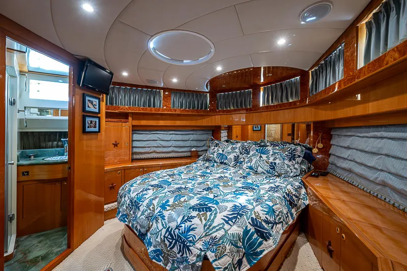 Slide: The Image of Luxurious bedroom in 2013 Johnson 78 Cockpit Motoryacht with wood paneling and floral bedding. - 49