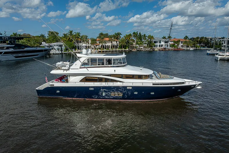 Slide: The Image of 2013 Johnson 78 Cockpit Motoryacht cruising on a sunny day, surrounded by waterfront homes. - 5