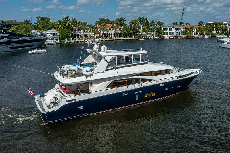 Slide: The Image of 2013 Johnson 78 Cockpit Motoryacht cruising on a scenic waterway. - 9
