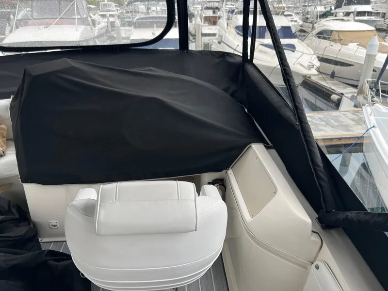 Slide: The Image of 1995 Cruisers Yachts 3650 ACMY cockpit with white seating and black cover, docked at marina. - 25