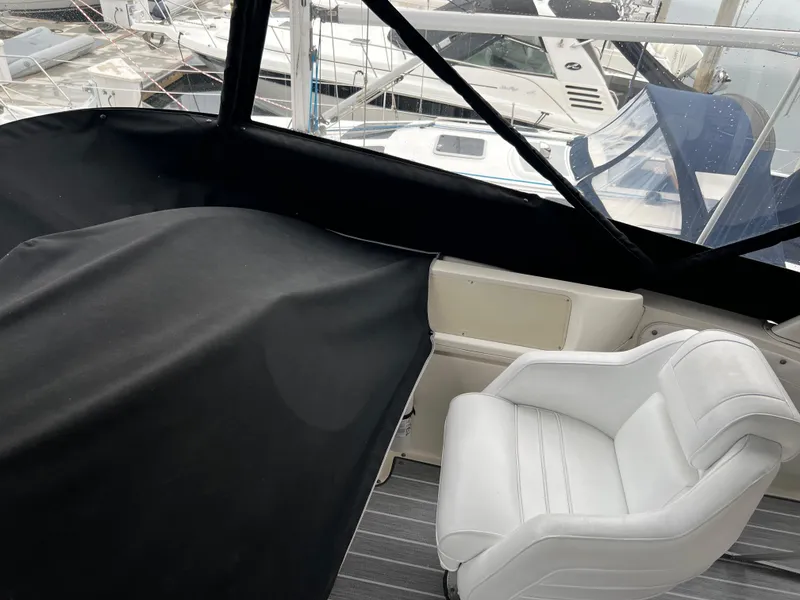 Slide: The Image of 1995 Cruisers Yachts 3650 ACMY cockpit with white seating and black cover, docked at marina. - 37