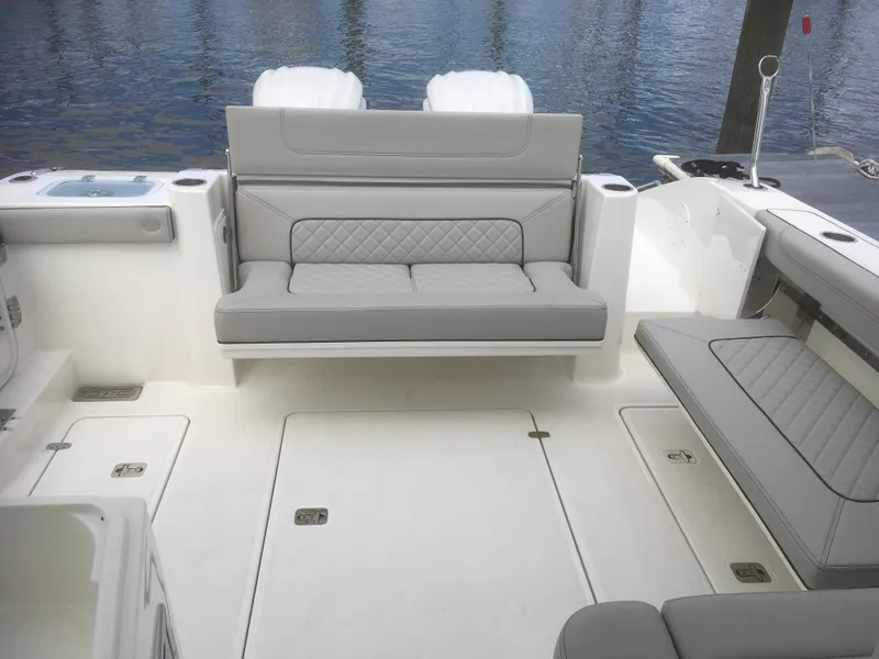 Slide: The Image of 2025 Pursuit DC 326 Dual Console boat interior with cushioned seating and storage compartments. - 4