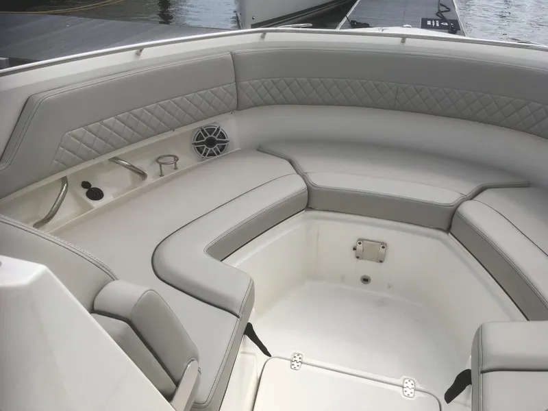 Slide: The Image of 2025 Pursuit DC 326 Dual Console boat interior with cushioned seating and speaker. - 8