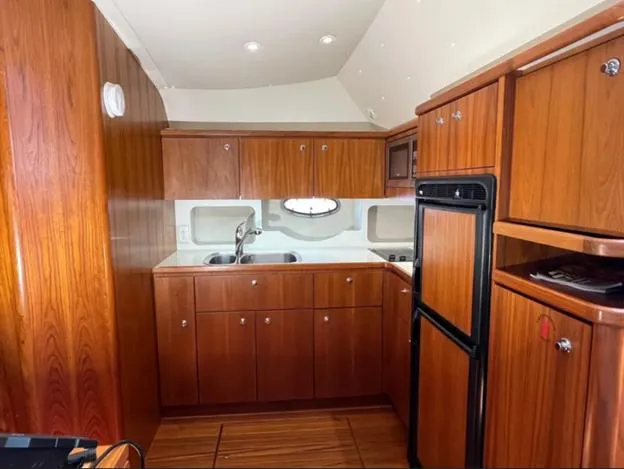 Slide: The Image of 1999 Tiara Yachts 4100 Open interior kitchen with wood cabinetry and modern appliances. - 17