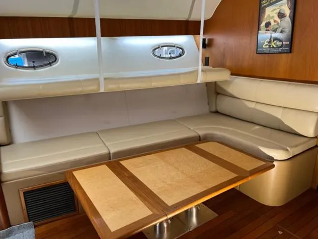 Slide: The Image of 1999 Tiara Yachts 4100 Open interior with beige seating and wooden table. - 2