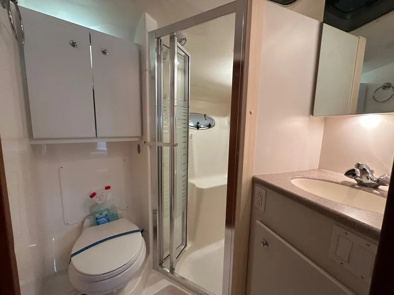 Slide: The Image of Bathroom interior of 1999 Tiara Yachts 4100 Open, featuring shower, toilet, and sink. - 23