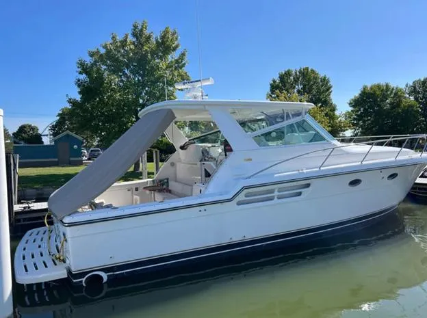 Slide: The Image of 1999 Tiara Yachts 4100 Open docked, showcasing sleek design and spacious deck. - 5