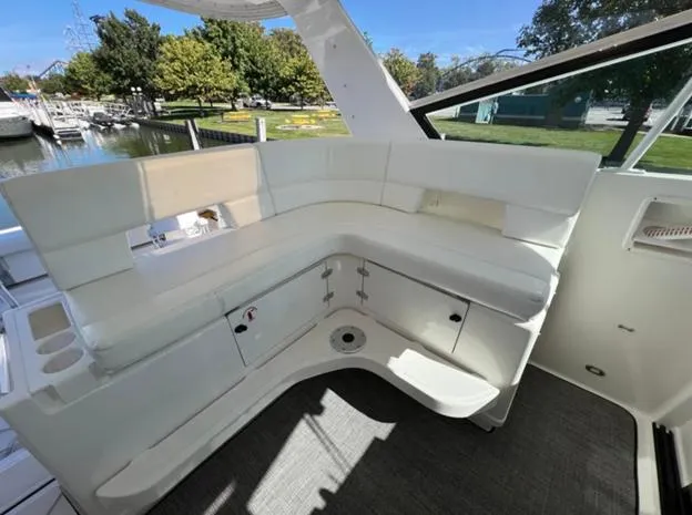 Slide: The Image of 1999 Tiara Yachts 4100 Open interior with white seating and storage, docked by a marina. - 7