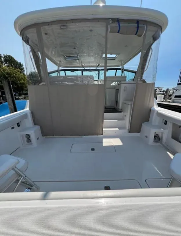 Slide: The Image of 1999 Tiara Yachts 4100 Open, spacious deck view, clear skies, marina background. - 9