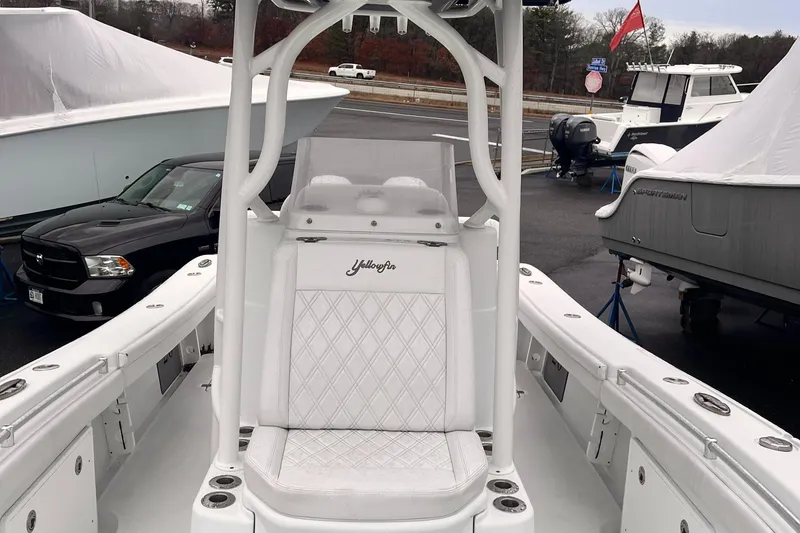 Slide: The Image of 2021 Yellowfin 26 Hybrid boat with white seating, docked in a marina. - 3