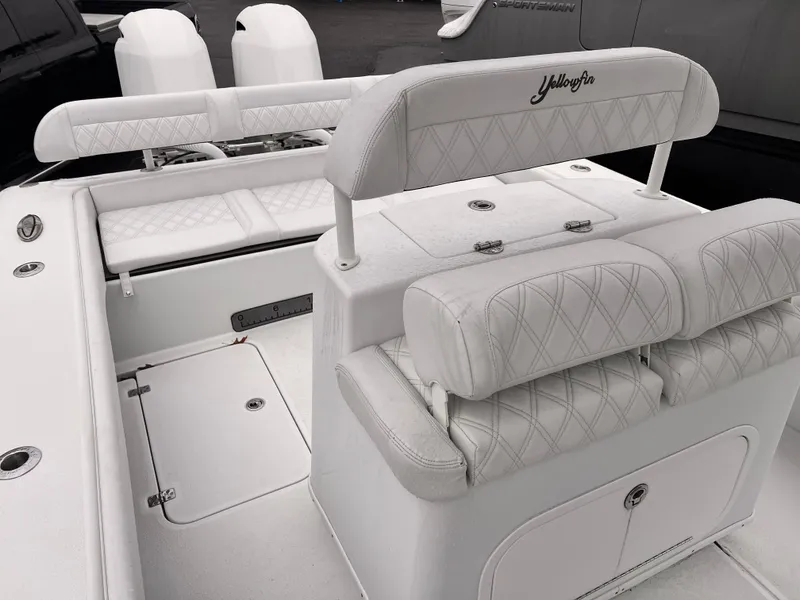 Slide: The Image of 2021 Yellowfin 26 Hybrid boat interior with white cushioned seating and storage compartments. - 5
