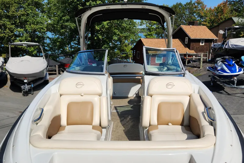 Slide: The Image of 2017 Crownline Eclipse E4 boat with tan seating, docked near cabins and trees. - 6