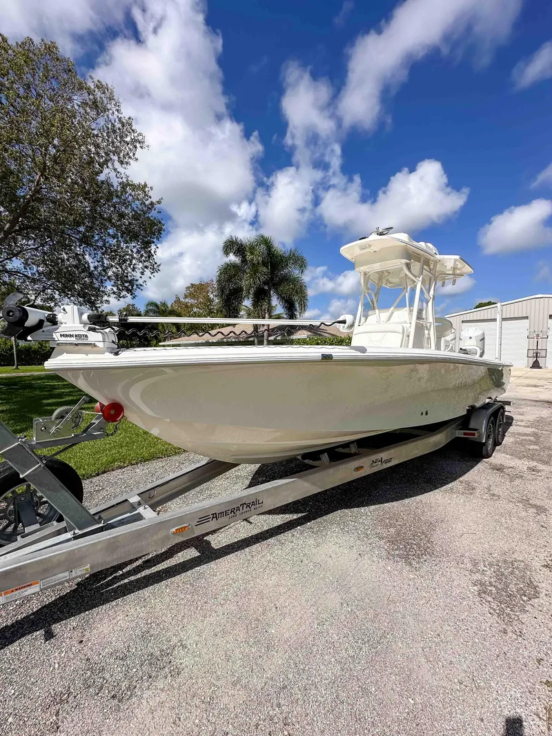 Slide: The Image of 2022 SeaVee 270Z boat on trailer under a clear blue sky. - 12