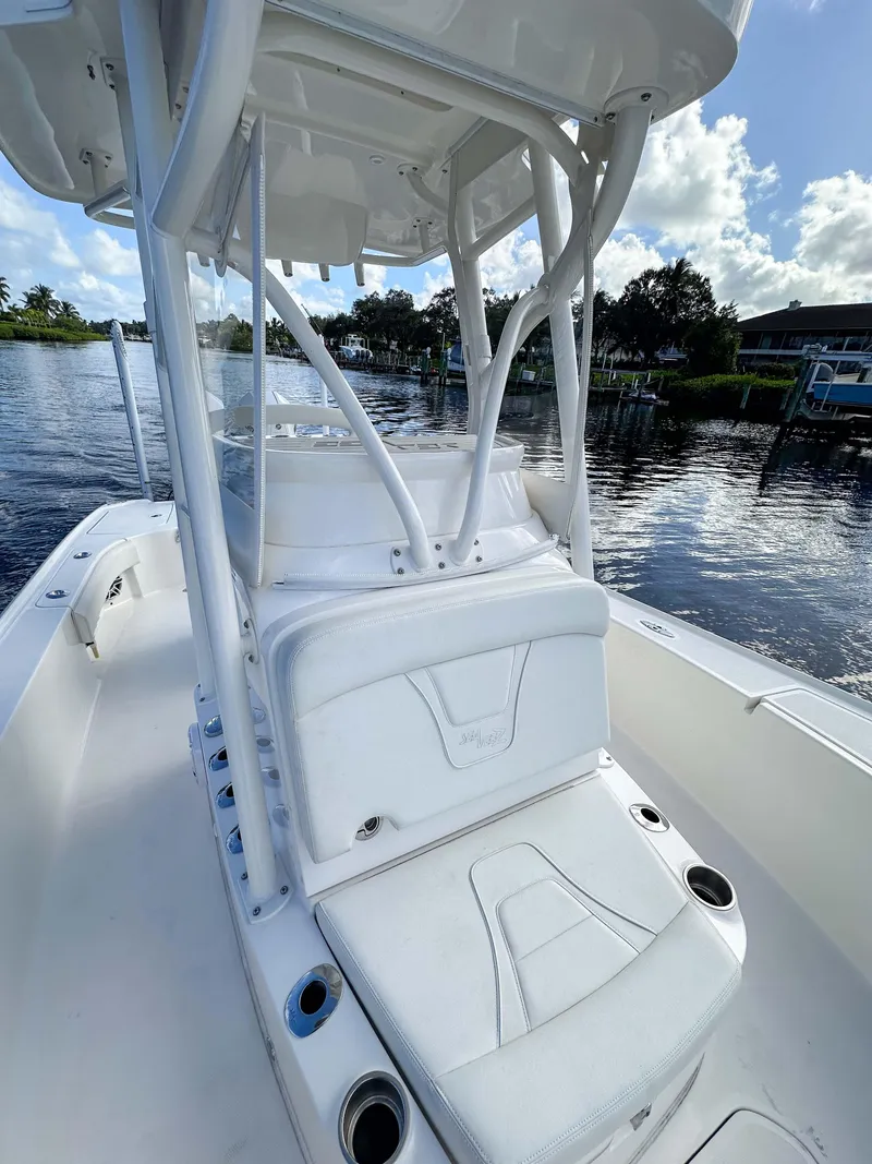 Slide: The Image of 2022 SeaVee 270Z boat with white seating and T-top on a calm waterway. - 20