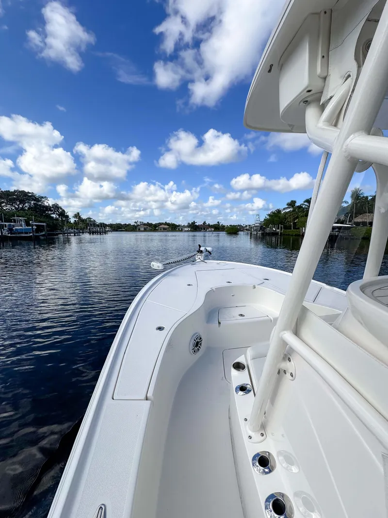 Slide: The Image of 2022 SeaVee 270Z boat on a calm river under a blue sky with clouds. - 25