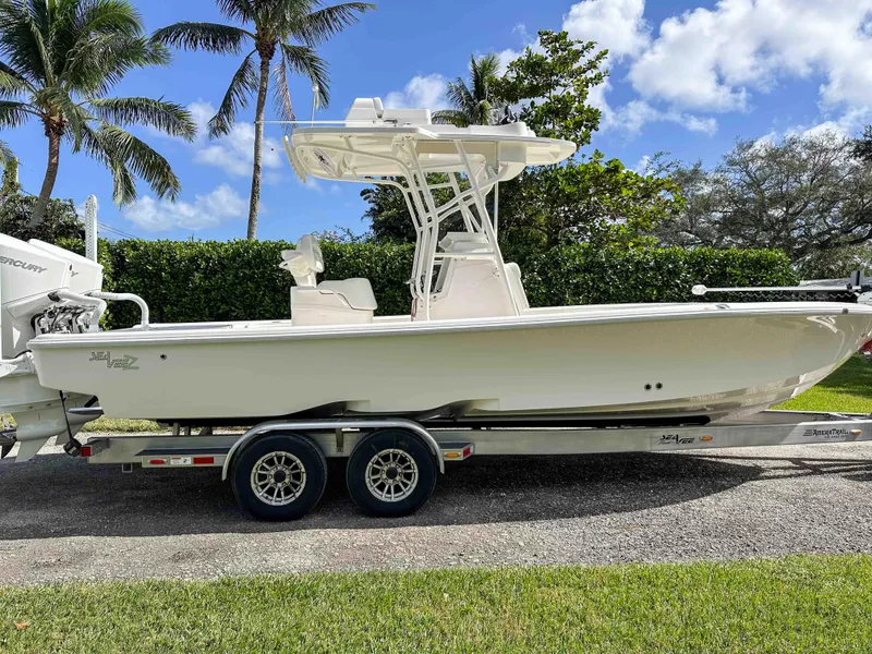 Slide: The Image of 2022 SeaVee 270Z boat on trailer, parked outdoors with palm trees in the background. - 5